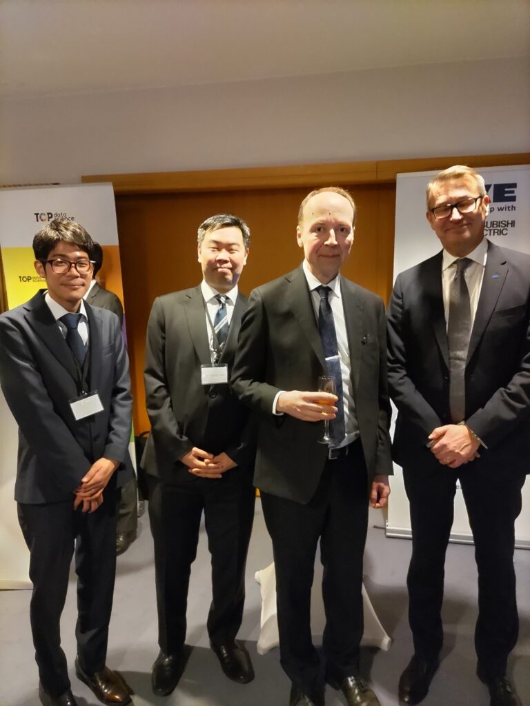 4 business men in suits pose for a photograph